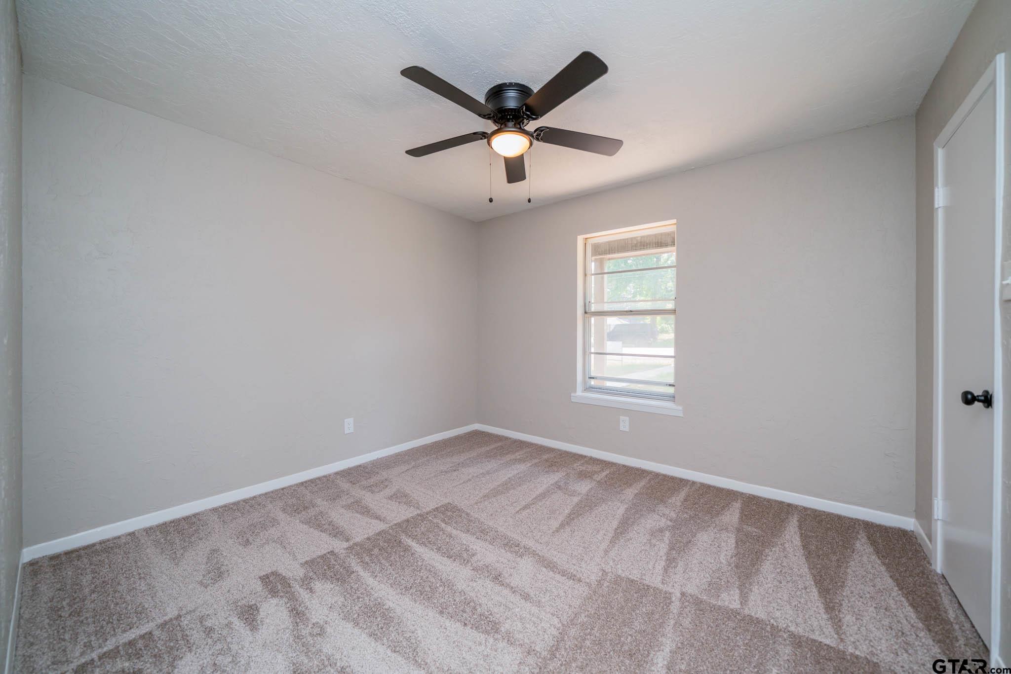 1411 Sapphire Street Longview, TX 75602 - Photo 28 of 38 an empty room with ceiling fan and window