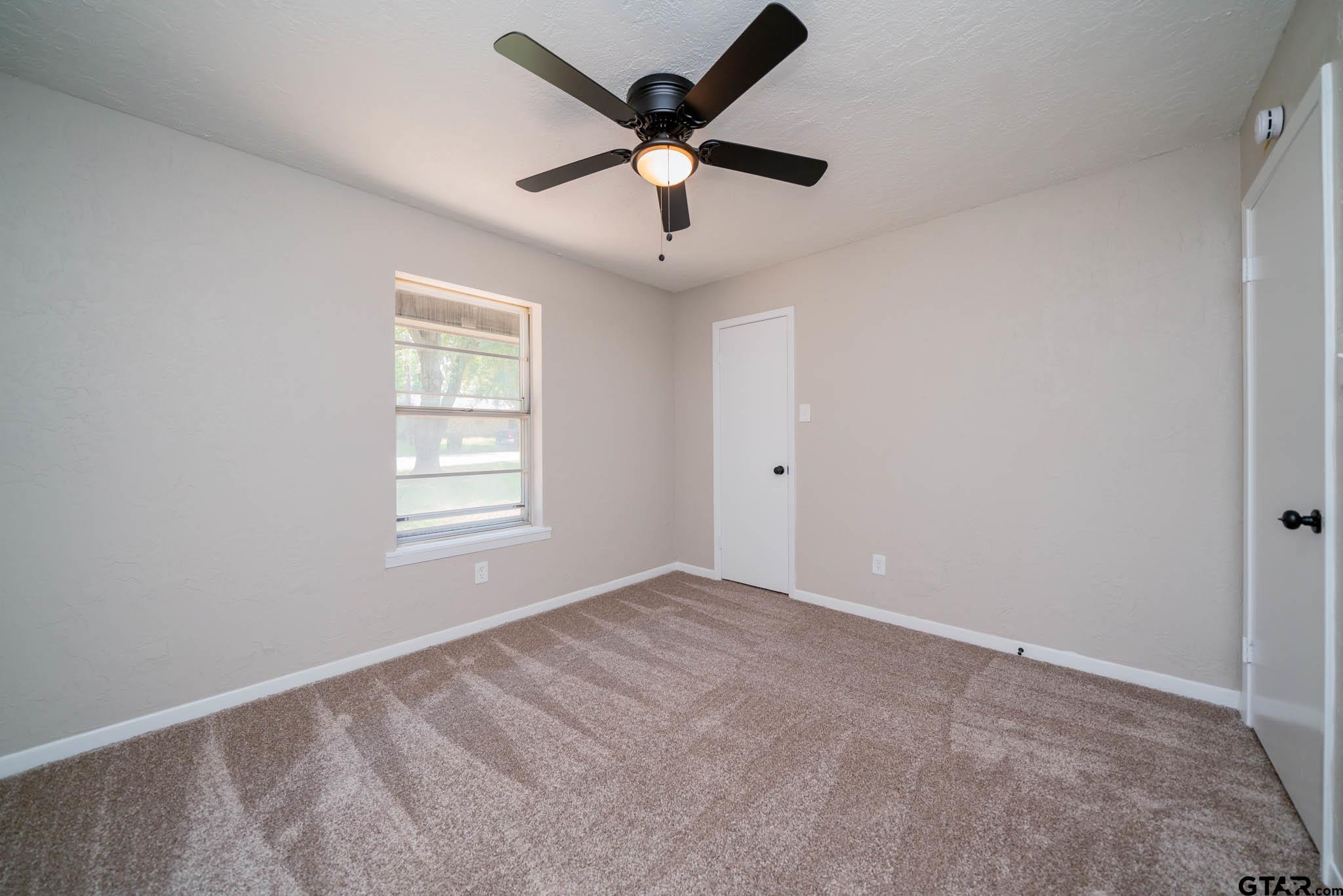 1411 Sapphire Street Longview, TX 75602 - Photo 29 of 38 a view of an empty room with window and a ceiling fan