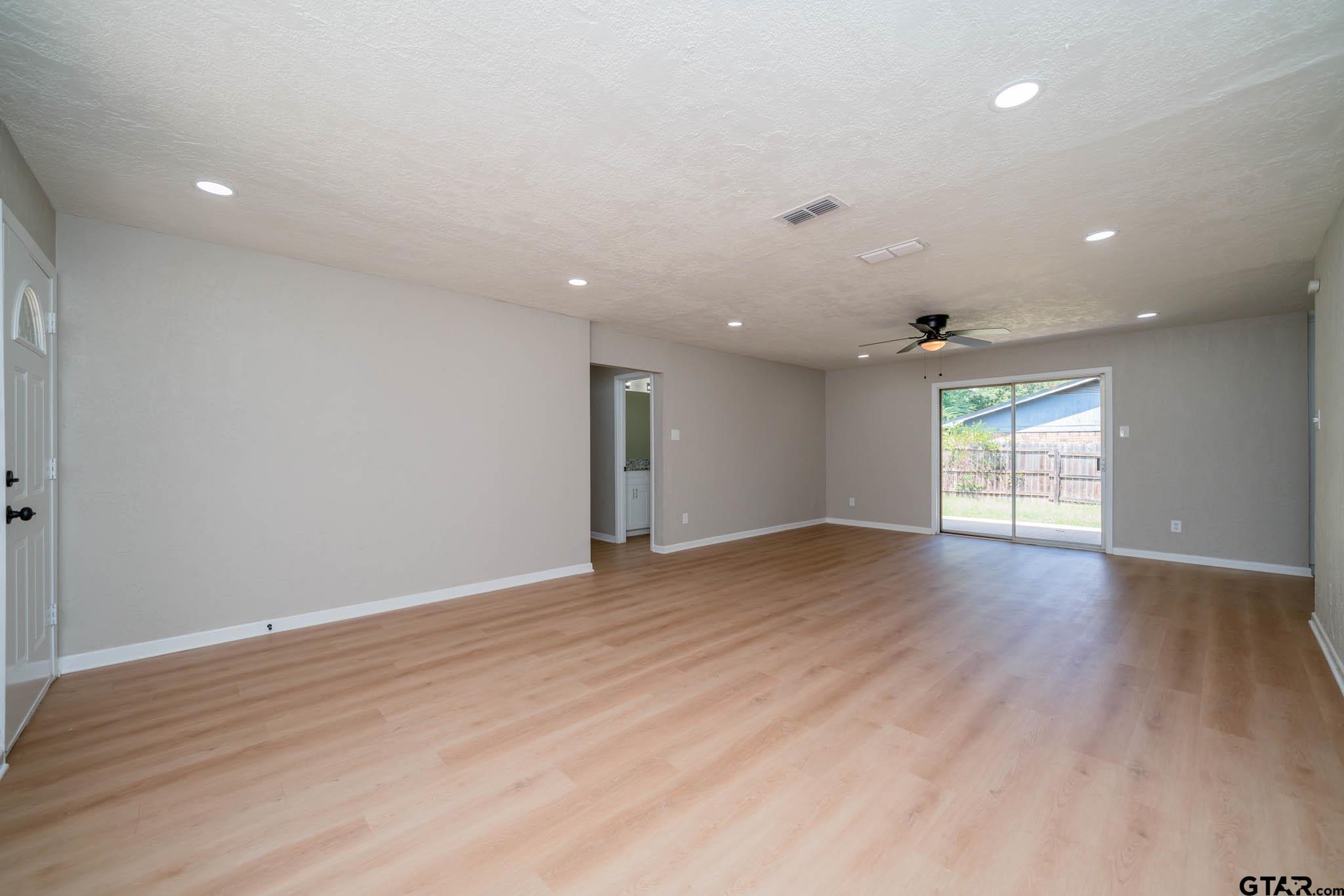1411 Sapphire Street Longview, TX 75602 - Photo 10 of 38 an empty room with wooden floor and windows