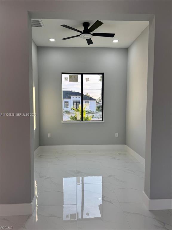 3414 4th Street Southwest Lehigh Acres, FL 33976 - Photo 12 of 28 an empty room with windows and ceiling fan