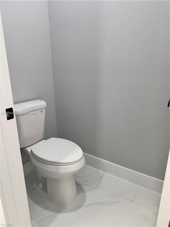 3414 4th Street Southwest Lehigh Acres, FL 33976 - Photo 19 of 28 a white toilet sitting next to a white sink