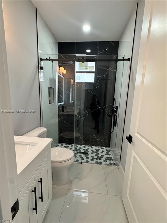 3414 4th Street Southwest Lehigh Acres, FL 33976 - Photo 21 of 28 a bathroom with a sink a toilet and shower