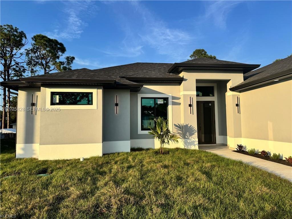 3414 4th Street Southwest Lehigh Acres, FL 33976 - Photo 4 of 28 a front view of a house with garden