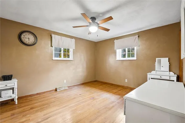 a view of a livingroom with wooden floor and a ceiling fan