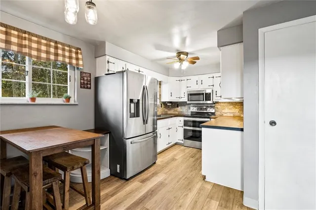 a kitchen with stainless steel appliances a refrigerator and a stove top oven