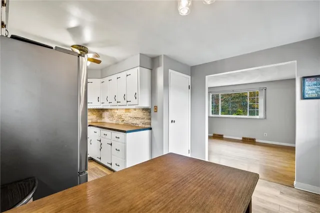 a kitchen with a stove a refrigerator and a wooden floor