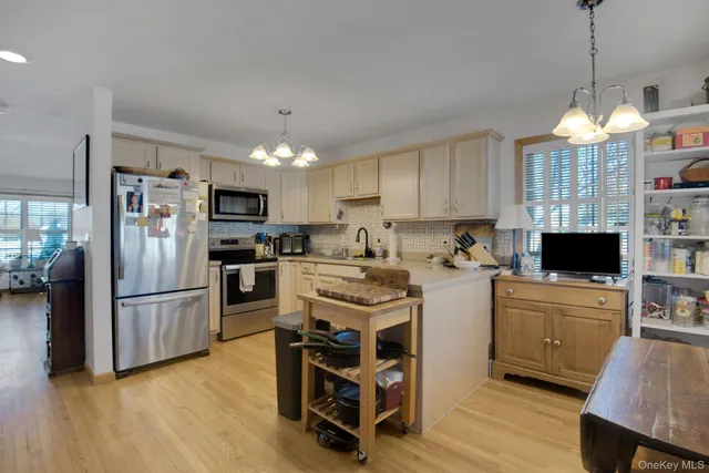 a kitchen with refrigerator a stove a sink dishwasher a oven with a dining table and chairs