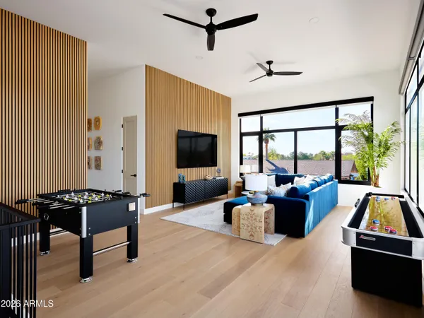 a living room with furniture a flat screen tv and a large window