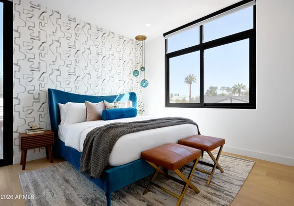 a bedroom with furniture and large windows