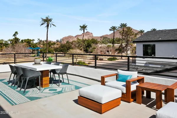 a living room with patio furniture and a potted plant