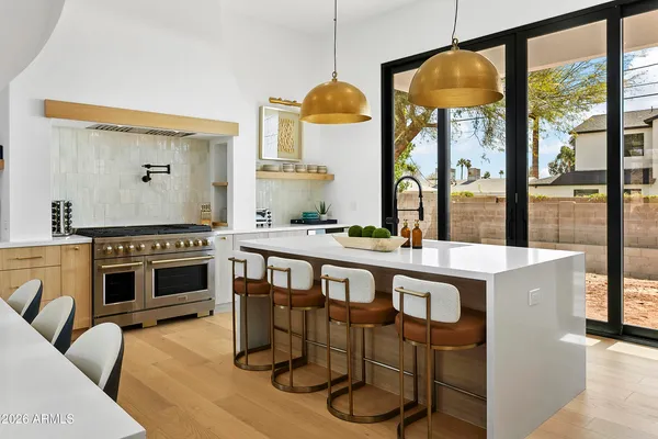 a kitchen with stainless steel appliances granite countertop a stove a sink and a refrigerator