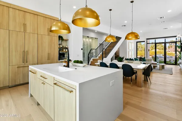 a view of a dining room and livingroom with furniture wooden floor a chandelier