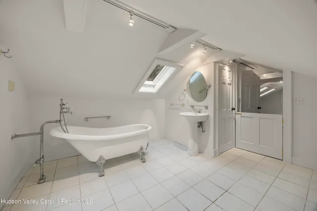 a spacious bathroom with a sink a toilet and a mirror