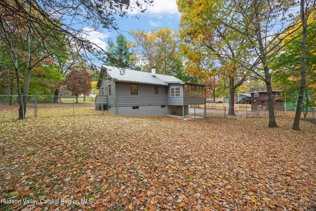 a backyard of a house with large trees and a small yard