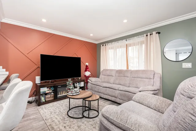 a living room with furniture a flat screen tv and a large window