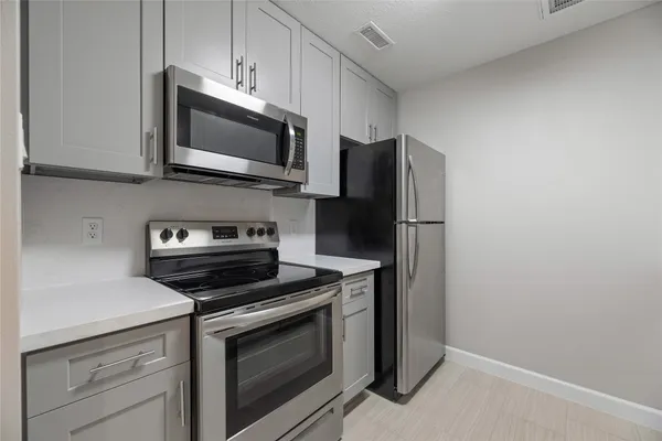 a kitchen with stainless steel appliances a stove microwave and sink