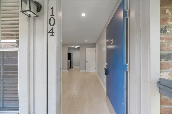 a view of a hallway with a door and stairs