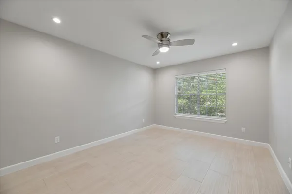 an empty room with a window and a fan