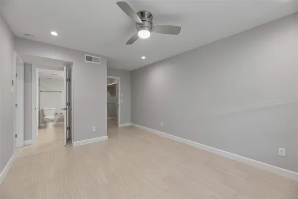 an empty room with fan and entrance