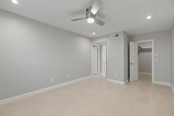 an empty room with a ceiling fan and a window