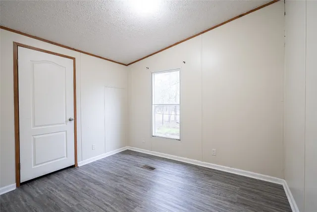 an empty room with wooden floor and window