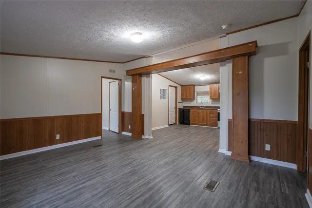 a view of an empty room with wooden floor and a cabinet