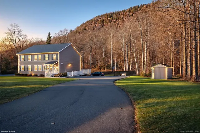 a front view of a house with a yard and trees