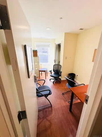 a view of a workspace with furniture and a window