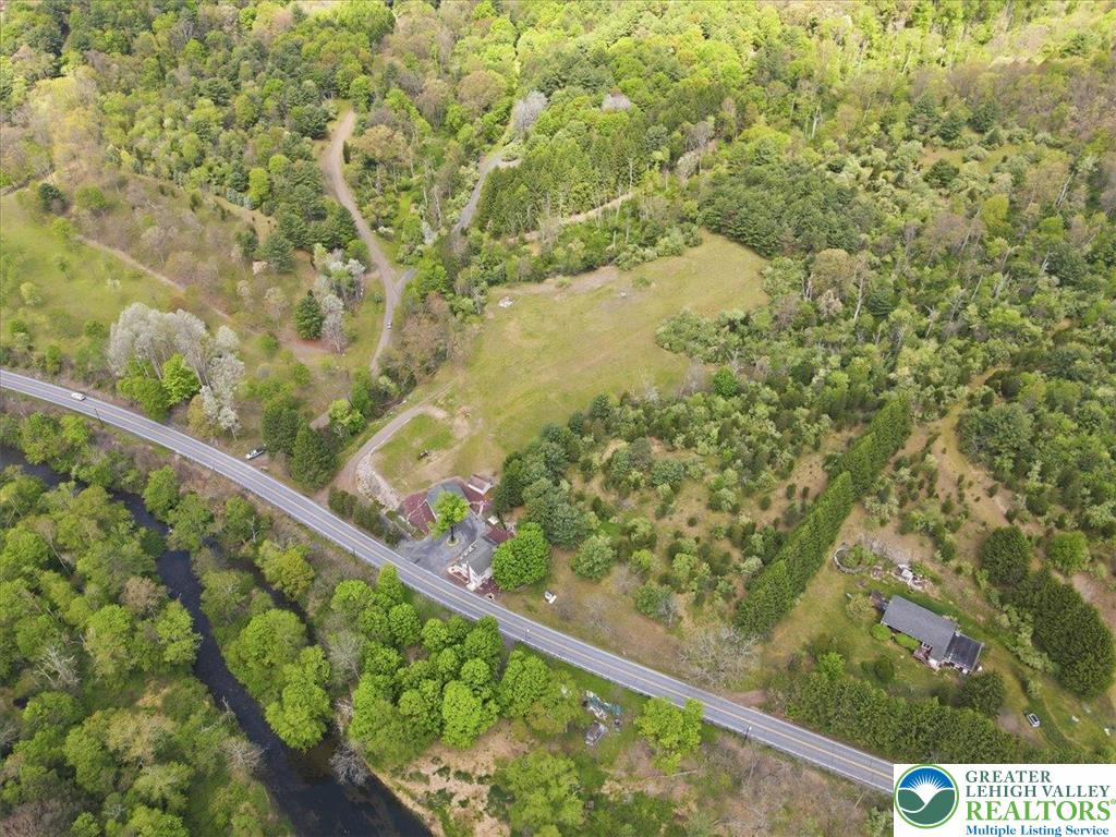 4880 Little Gap Road Kunkletown, PA 18058 - Photo 94 of 100 This elevated view captures a serene landscape with a tranquil river flowing alongside verdant trees.
