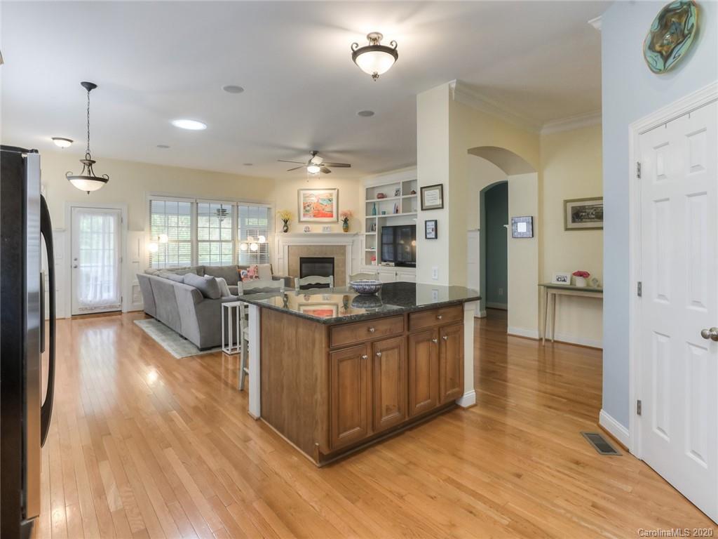 899 Stratford Run Drive Fort Mill, SC 29708 - Photo 16 of 48 a kitchen with stainless steel appliances granite countertop a refrigerator a sink dishwasher a oven and a dining table with wooden floor
