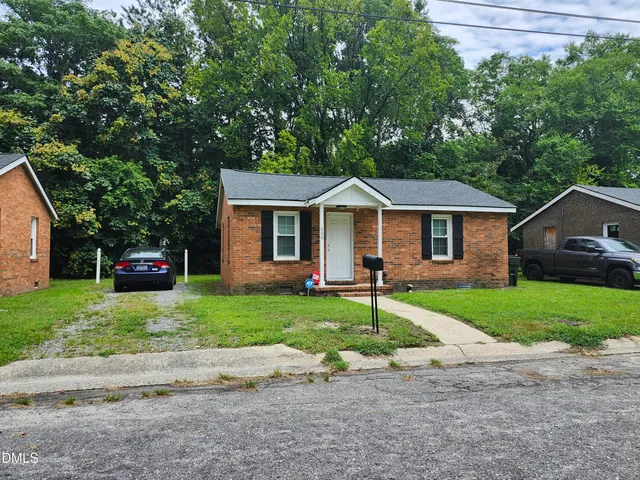 a front view of a house with a yard and trees