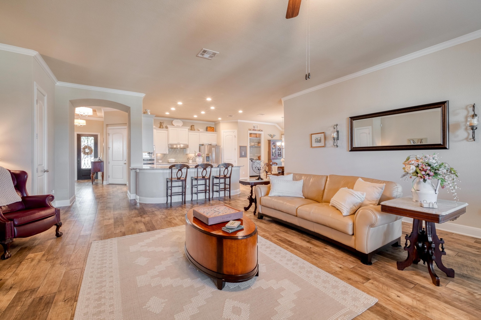 3204 Venezia View Leander, TX 78641 - Photo 4 of 28 Living room looking to kitchen and foyer with luxury vinyl plank flooring, tall ceilings, decorative molding and natural light