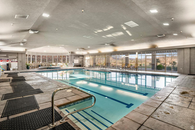 1587 Whitestone Drive St. George, UT 84790 - Photo 33 of 36 Indoor swimming pool featuring a tiled deck, integrated spa area, floor-to-ceiling windows, and recessed ceiling lighting