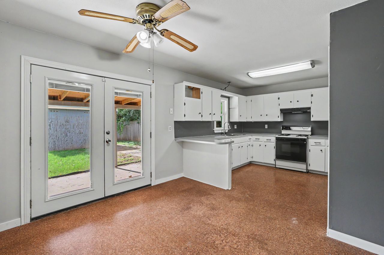 1811 Terry Lane Georgetown, TX 78628 - Photo 9 of 40 A well-appointed kitchen features ample cabinetry and a convenient breakfast bar, with French doors opening to the private outdoor space.