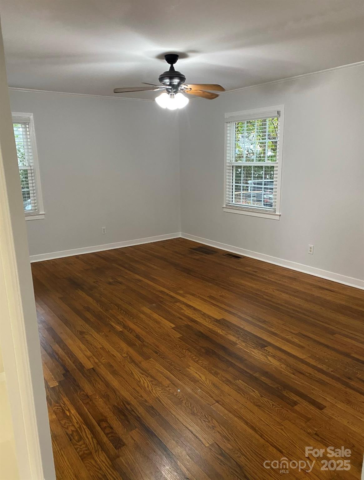 4100 Howie Circle Charlotte, NC 28205 - Photo 5 of 8 an empty room with wooden floor chandelier fan and windows