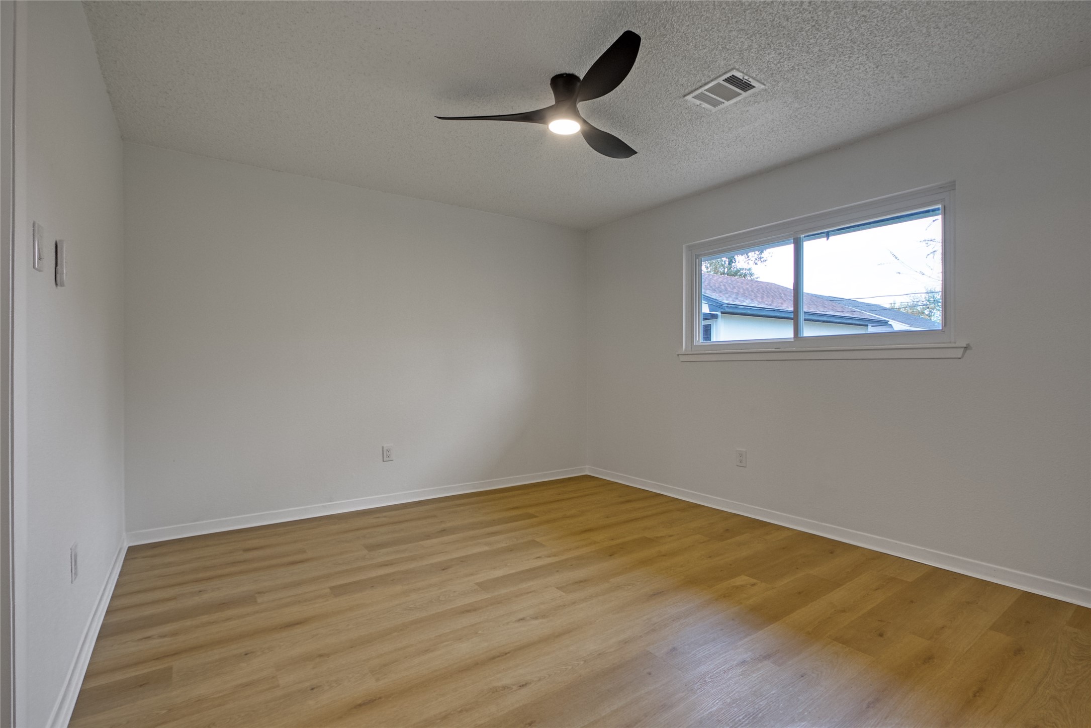 5802 Chrystell Lane Houston, TX 77092 - Photo 12 of 17 an empty room with a window and a ceiling fan