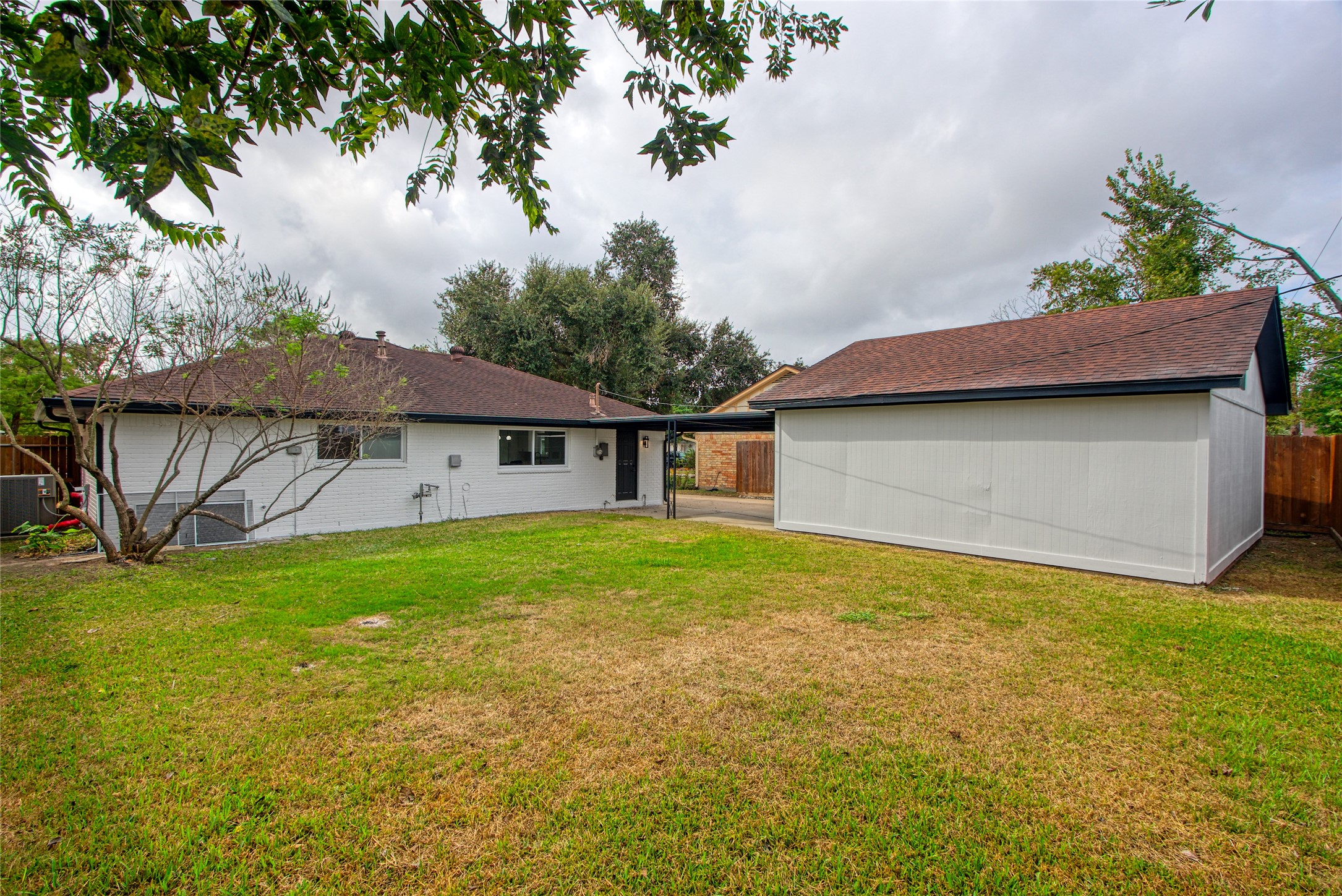 5802 Chrystell Lane Houston, TX 77092 - Photo 15 of 17 a backyard of a house with table and chairs under an umbrella