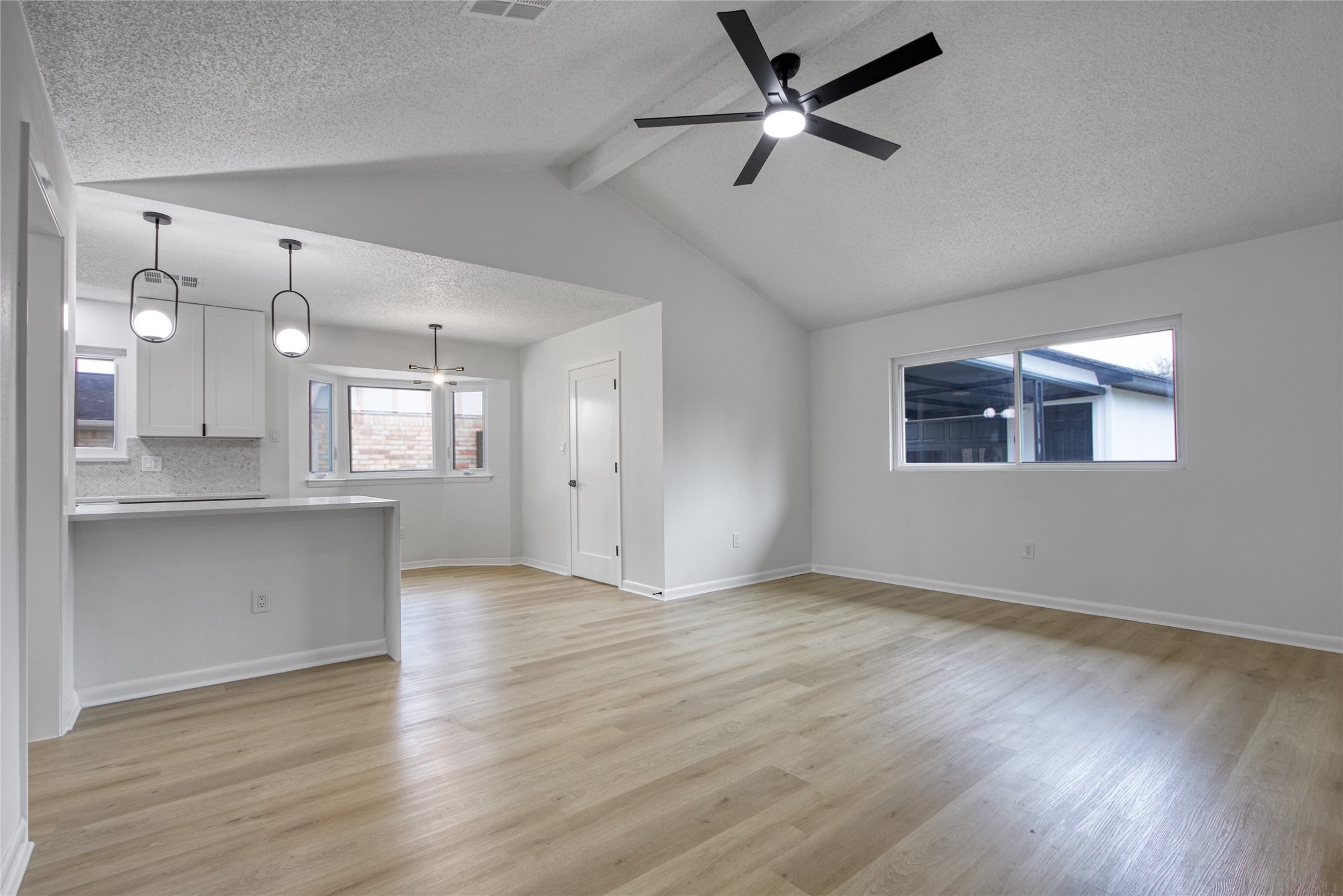 5802 Chrystell Lane Houston, TX 77092 - Photo 7 of 17 a view of an empty room with wooden floor and a kitchen