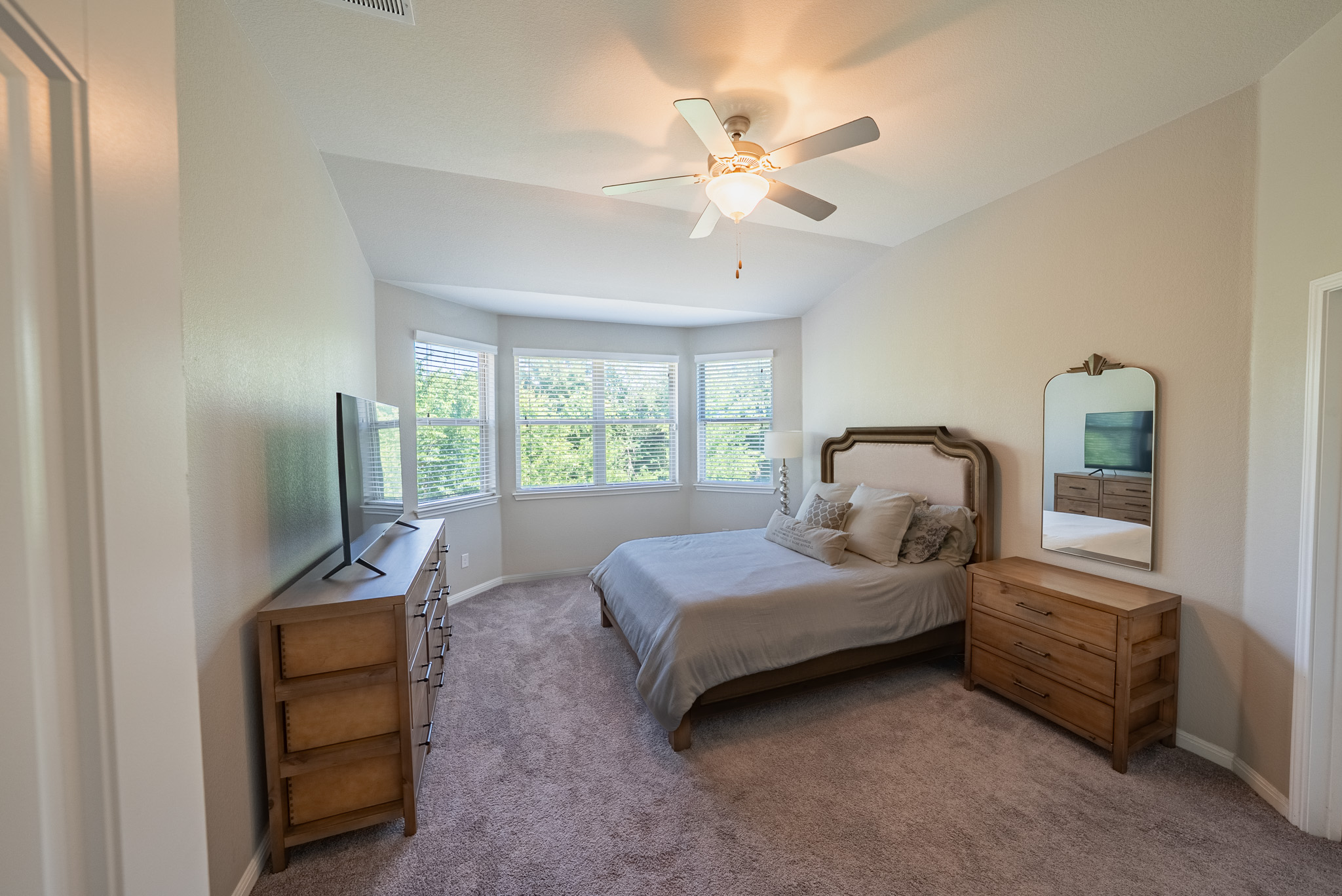 2508 Hat Bender Loop Round Rock, TX 78664 - Photo 10 of 22 Vaulted ceiling room with multiple windows, neutral carpet flooring, and a ceiling fan with integrated lighting