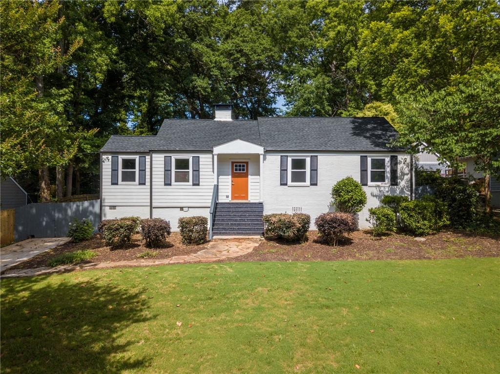 a front view of a house with a yard and trees