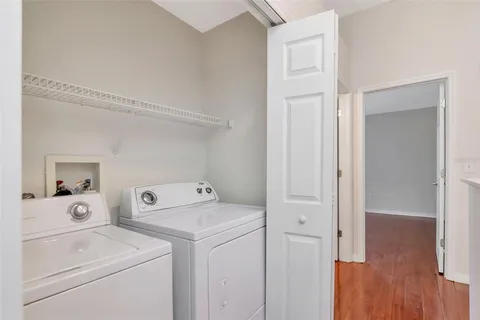 a view of washer and dryer with bathroom in the background