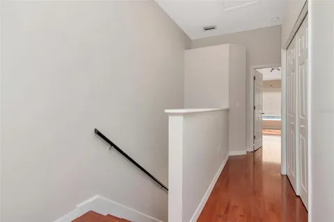 a view of a hallway with wooden floor and entryway