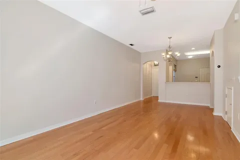 a view of a big room with wooden floor and a ceiling fan
