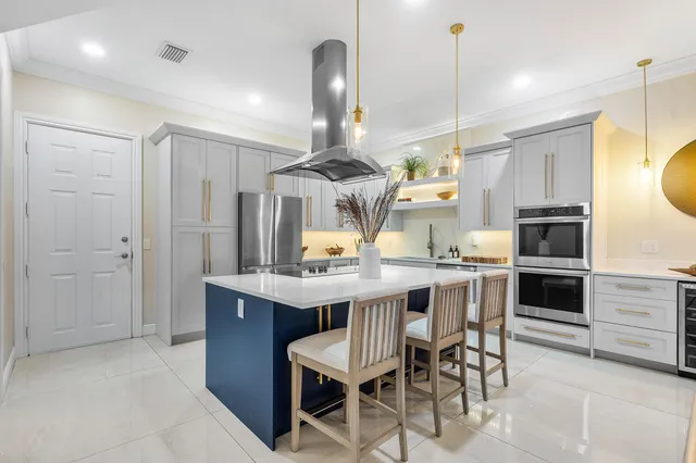a kitchen with stainless steel appliances a dining table chairs stove and refrigerator