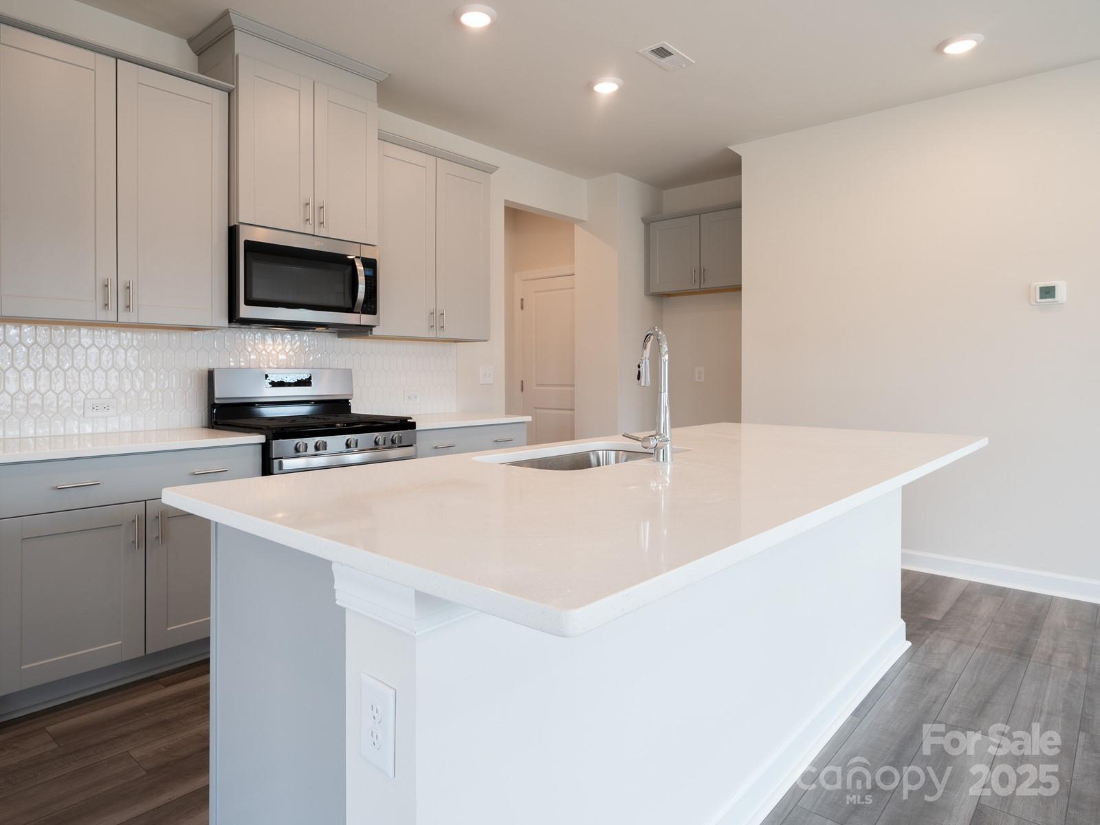 1441 31st Street Northeast Conover, NC 28613 - Photo 6 of 20 a kitchen with stainless steel appliances a sink a stove a microwave and cabinets
