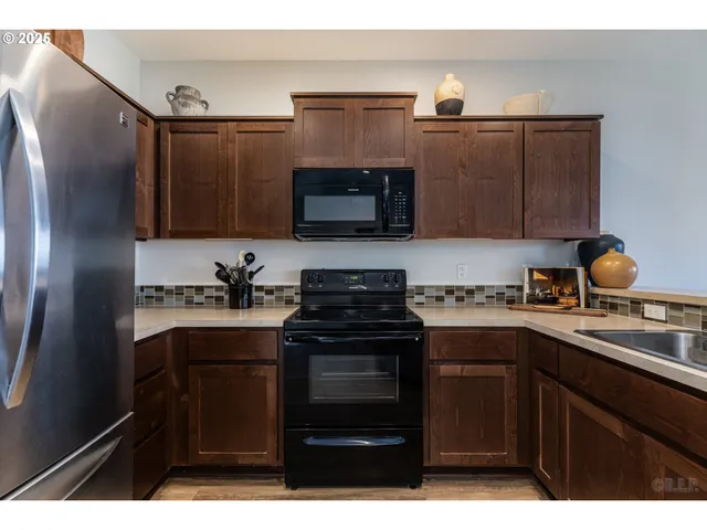a kitchen with granite countertop a sink cabinets and stainless steel appliances