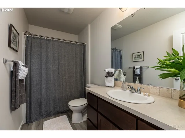 a bathroom with a sink a toilet a mirror and shower