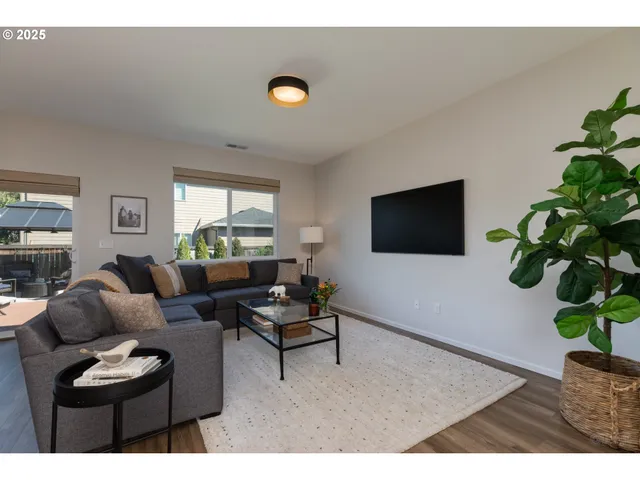 a living room with furniture a window and a flat screen tv