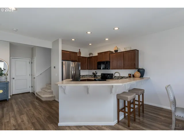 a kitchen with stainless steel appliances a refrigerator and a stove top oven