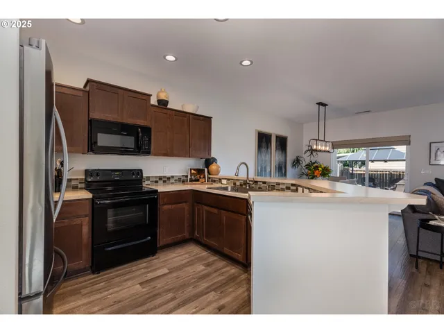 a kitchen with kitchen island a sink stainless steel appliances and cabinets